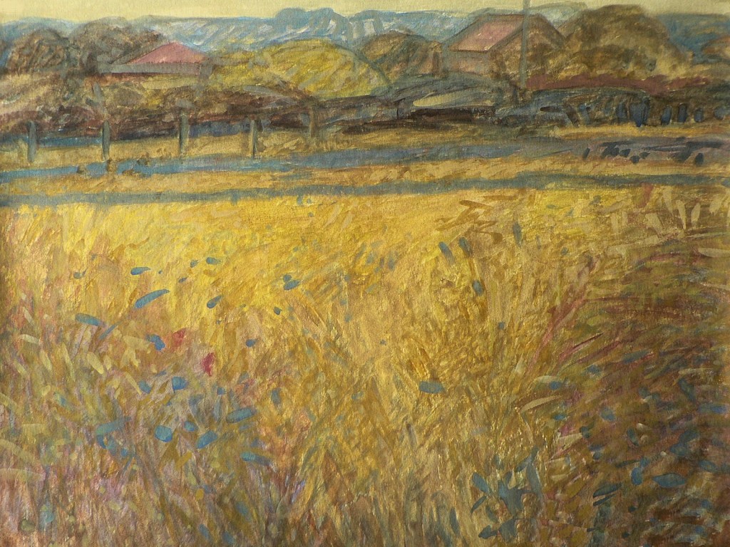Pejzaż wiejski namalowany gwaszem. Przedstawia zachwaszczony kwiatami malowniczy łan zboża. W oddali pośród drzew dachy domów rysują linię horyzontu.